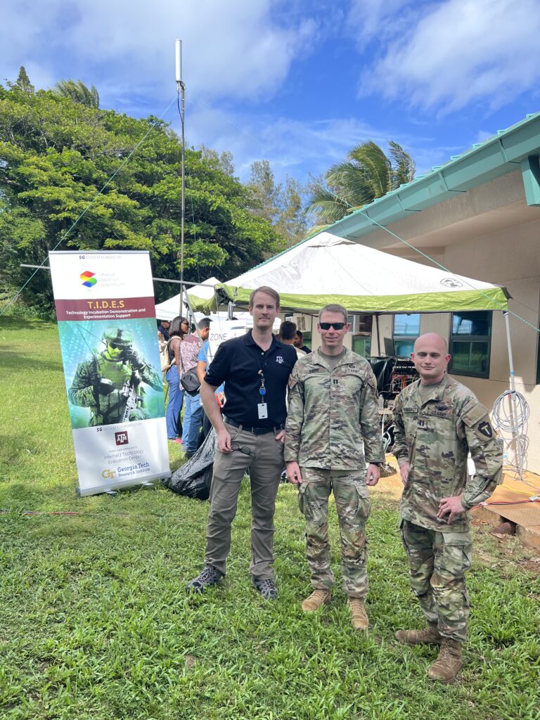 Derek LADD with TIDES attendees in front of ITEC tent