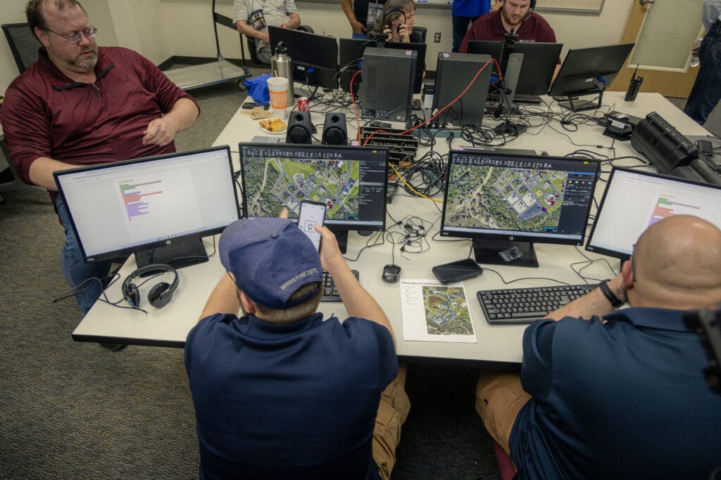 public safety professionals in front of computers in a safety exercise.